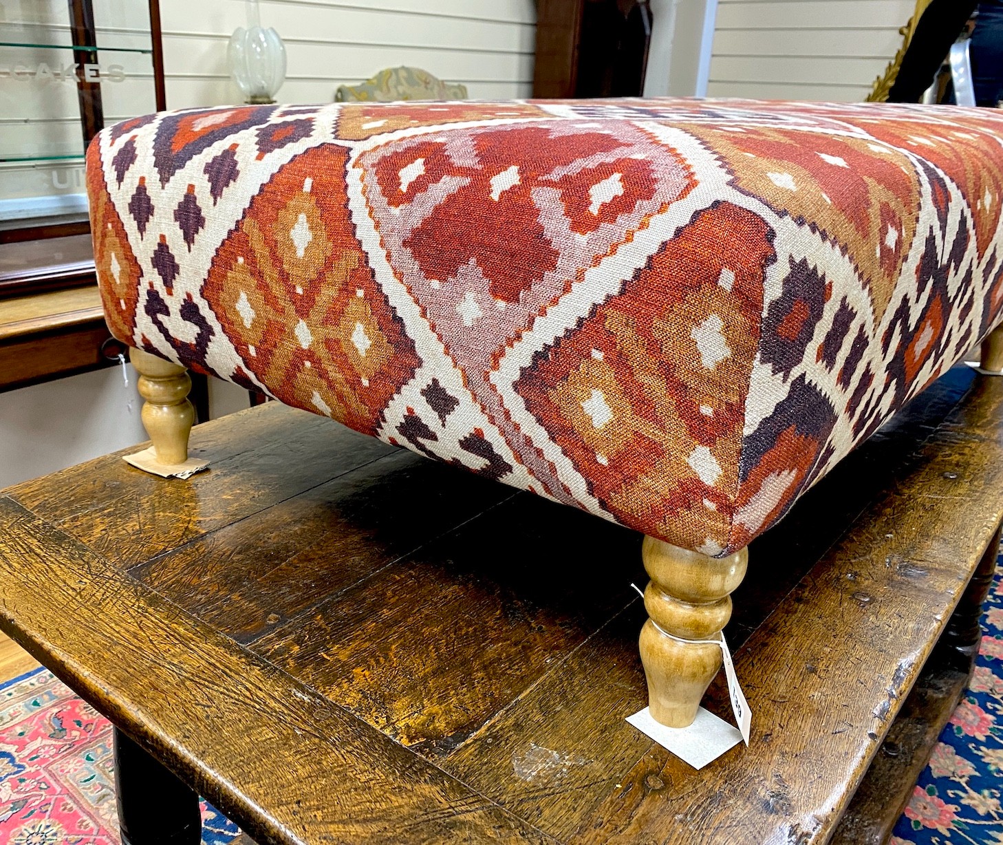 A large contemporary rectangular footstool upholstered in Kilim style fabric on turned beech feet, length 125cm, depth 74cm, height 39cm